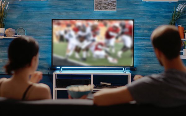 CTV Advertising. Stock image of two people watching a football game on TV