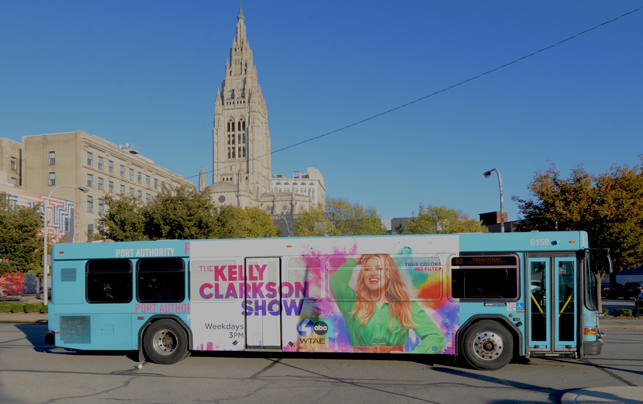 City bus featuring an out-of-home advertisement for the "Kelly Clarkson Show," with vibrant graphics and show branding displayed prominently along the side of the vehicle.
